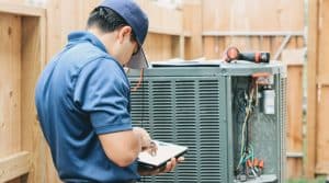HVAC technician inspects an air conditioning system outside